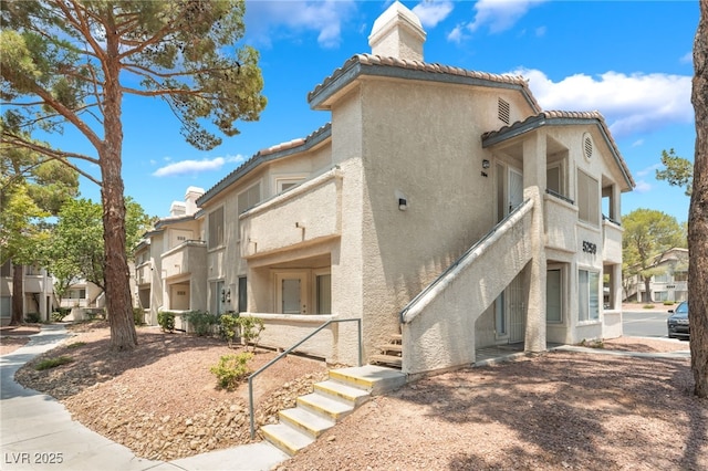 5259 Caspian Springs Dr Unit 204, Las Vegas, NV 89120 - view of building exterior with stairway and a residential view