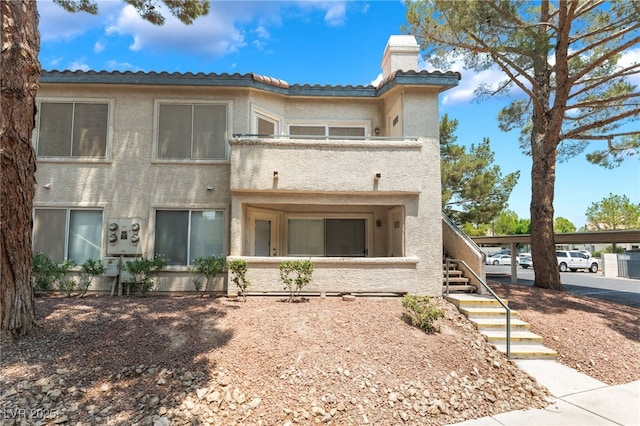 5259 Caspian Springs Dr Unit 204, Las Vegas, NV 89120 - rear view of house featuring stucco siding, a chimney, stairway, and a tiled roof