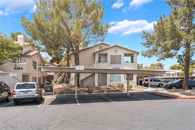5259 Caspian Springs Dr Unit 204, Las Vegas, NV 89120 - view of front of home with covered and uncovered parking, stucco siding, and stairs