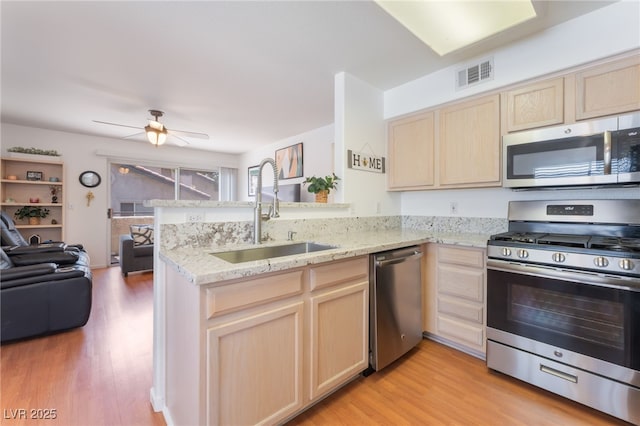 5259 Caspian Springs Dr Unit 204, Las Vegas, NV 89120 - kitchen featuring appliances with stainless steel finishes, light brown cabinetry, a peninsula, and open floor plan