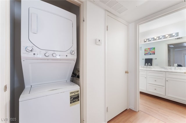 5259 Caspian Springs Dr Unit 204, Las Vegas, NV 89120 - washroom with stacked washing machine and dryer and light wood finished floors