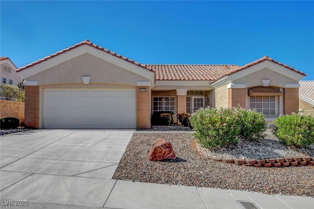 10724 Windledge Ave, Las Vegas, NV 89134 - mediterranean / spanish home featuring concrete driveway, a garage, a tile roof, and stucco siding