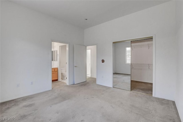 10724 Windledge Ave, Las Vegas, NV 89134 - unfurnished bedroom featuring light carpet, a closet, and ensuite bath