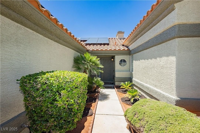 4813 W Virginia Falls Ln, Las Vegas, NV 89130 - property entrance featuring a tiled roof, stucco siding, and solar panels