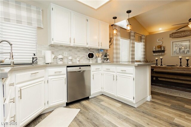 4813 W Virginia Falls Ln, Las Vegas, NV 89130 - kitchen with stainless steel dishwasher, vaulted ceiling, light wood-style flooring, a peninsula, and white cabinetry