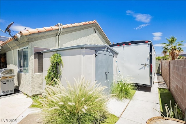 4813 W Virginia Falls Ln, Las Vegas, NV 89130 - view of home's exterior with a fenced backyard, a tiled roof, stucco siding, and a storage shed