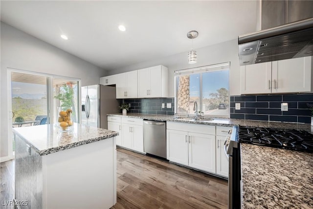6552 Sweetzer Way, Las Vegas, NV 89108 - kitchen featuring stainless steel appliances, extractor fan, vaulted ceiling, plenty of natural light, and white cabinetry