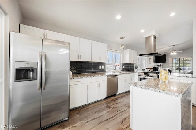 6552 Sweetzer Way, Las Vegas, NV 89108 - kitchen with appliances with stainless steel finishes, island range hood, plenty of natural light, white cabinets, and recessed lighting
