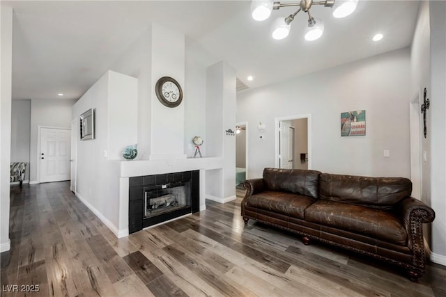 6552 Sweetzer Way, Las Vegas, NV 89108 - living room with wood finished floors, a chandelier, a tile fireplace, and recessed lighting
