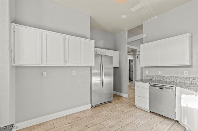 5616 Royal Castle Ln, Las Vegas, NV 89130 - kitchen featuring stainless steel appliances, white cabinetry, light stone countertops, and wood finish floors