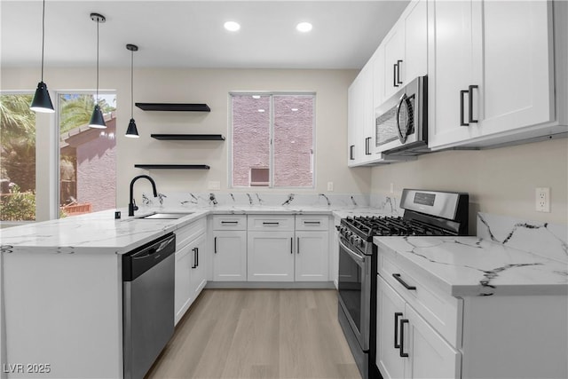 2118 High Mesa Dr, Henderson, NV 89012 - kitchen featuring appliances with stainless steel finishes, open shelves, white cabinetry, light wood-style flooring, and a peninsula