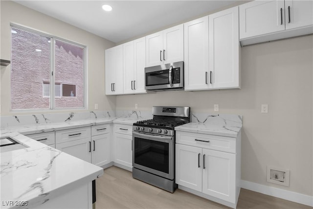 2118 High Mesa Dr, Henderson, NV 89012 - kitchen with stainless steel appliances, light wood finished floors, light stone countertops, white cabinets, and recessed lighting