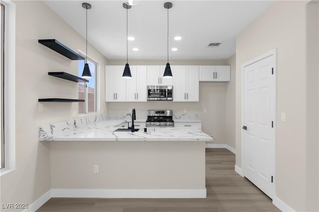 2118 High Mesa Dr, Henderson, NV 89012 - kitchen with stainless steel appliances, open shelves, a peninsula, white cabinetry, and decorative light fixtures