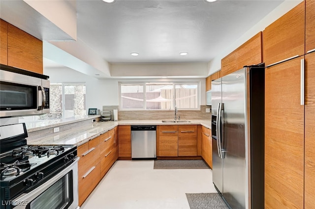2095 Mohigan Way, Las Vegas, NV 89169 - kitchen featuring appliances with stainless steel finishes, brown cabinets, light stone countertops, recessed lighting, and tasteful backsplash