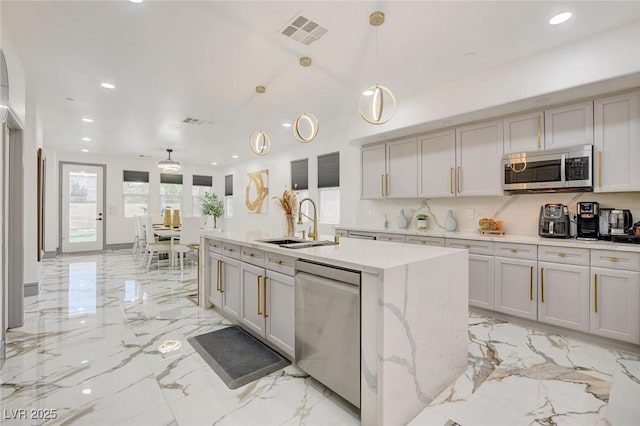 7024 Geese Gathering St, North Las Vegas, NV 89084 - kitchen featuring appliances with stainless steel finishes, recessed lighting, light marble finish flooring, a center island with sink, and hanging light fixtures