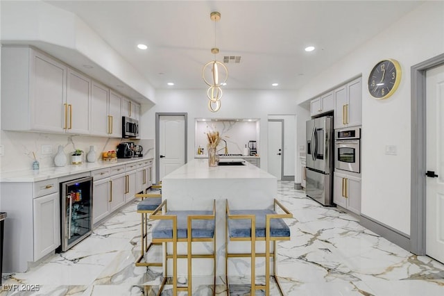 7024 Geese Gathering St, North Las Vegas, NV 89084 - kitchen with beverage cooler, stainless steel appliances, recessed lighting, light marble finish flooring, and light stone countertops
