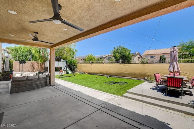 7024 Geese Gathering St, North Las Vegas, NV 89084 - fenced backyard with an outdoor hangout area, a patio area, a playground, a ceiling fan, and outdoor dining space