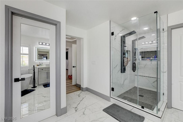 7024 Geese Gathering St, North Las Vegas, NV 89084 - full bathroom with marble look tile flooring, a marble finish shower, vanity, and a freestanding tub