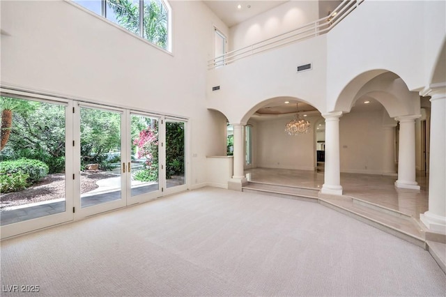 8021 Obannon Dr, Las Vegas, NV 89117 - unfurnished living room featuring decorative columns, carpet, a towering ceiling, and plenty of natural light