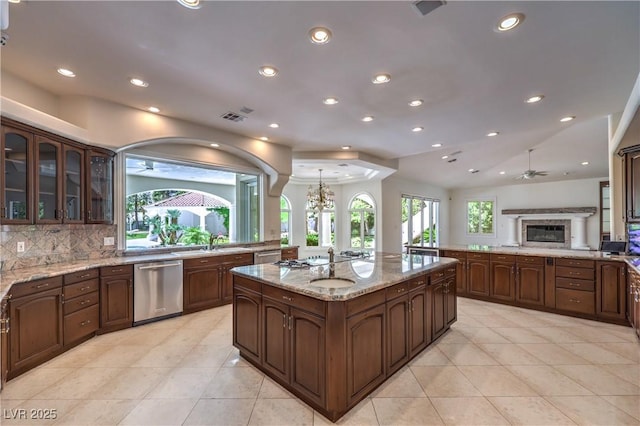 8021 Obannon Dr, Las Vegas, NV 89117 - kitchen featuring dishwasher, light tile patterned flooring, recessed lighting, glass insert cabinets, and a center island with sink