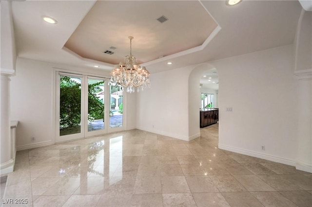 8021 Obannon Dr, Las Vegas, NV 89117 - empty room with healthy amount of natural light, arched walkways, a tray ceiling, recessed lighting, and a chandelier