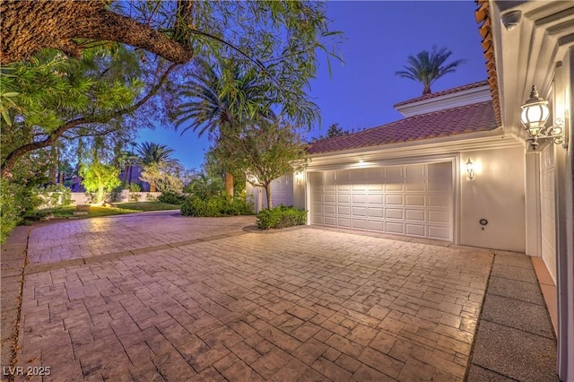 8021 Obannon Dr, Las Vegas, NV 89117 - garage at night featuring decorative driveway