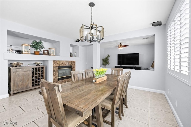 1141 Brent Park Ct, Henderson, NV 89002 - dining space with light tile patterned floors, a chandelier, a ceiling fan, and a fireplace