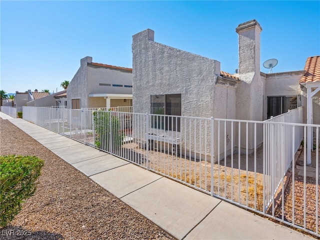 2214 Pebble Creek Ln, Laughlin, NV 89029 - view of front facade with stucco siding and a chimney