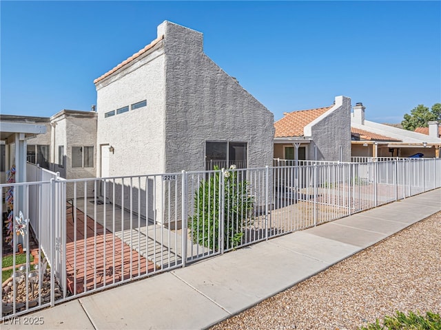 2214 Pebble Creek Ln, Laughlin, NV 89029 - view of side of home with stucco siding, a chimney, and a tile roof