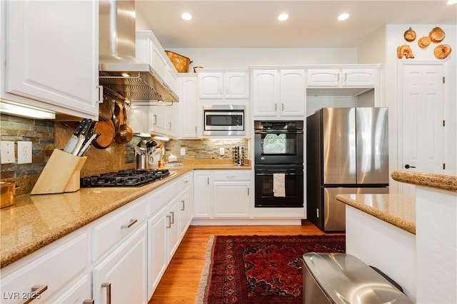 7209 Millerbird St, North Las Vegas, NV 89084 - kitchen with stainless steel appliances, wall chimney range hood, light wood finished floors, white cabinetry, and light stone counters