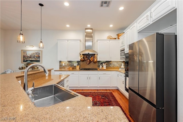 7209 Millerbird St, North Las Vegas, NV 89084 - kitchen featuring stainless steel appliances, wall chimney range hood, pendant lighting, white cabinets, and recessed lighting