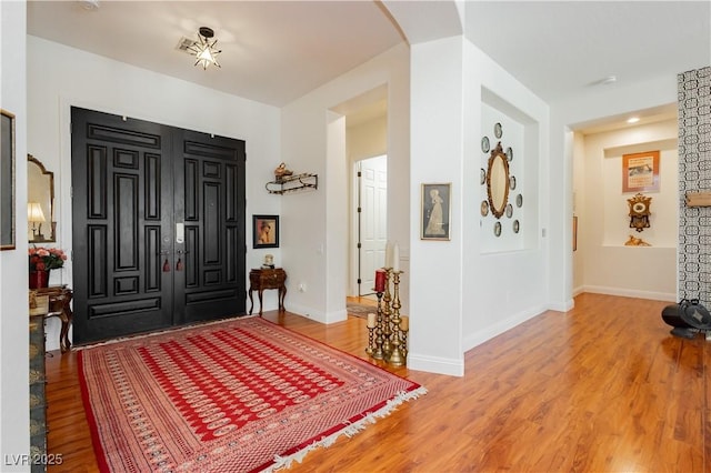 7209 Millerbird St, North Las Vegas, NV 89084 - foyer entrance with light wood finished floors and arched walkways