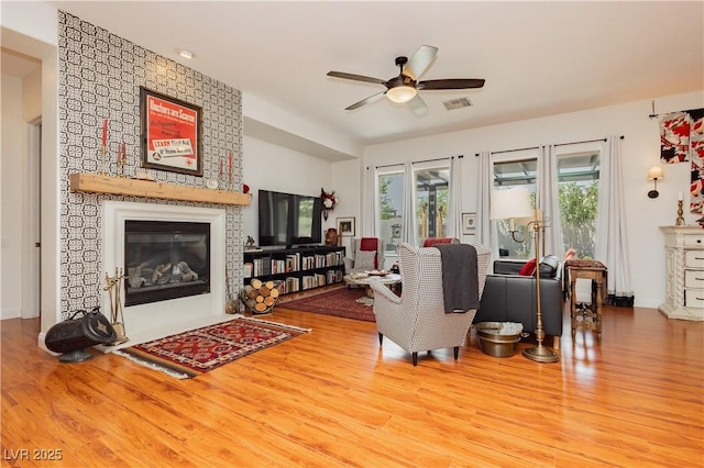 7209 Millerbird St, North Las Vegas, NV 89084 - living area featuring a large fireplace, ceiling fan, and wood finished floors