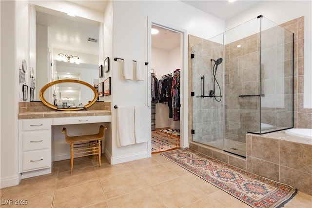 7209 Millerbird St, North Las Vegas, NV 89084 - full bathroom featuring tile patterned floors, a shower stall, a bath, vanity, and a spacious closet