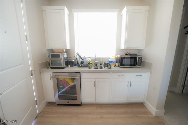 4182 Solace St, Las Vegas, NV 89135 - kitchen with beverage cooler, stainless steel microwave, and white cabinetry