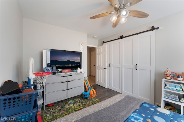 5243 Edna Crane Ave, North Las Vegas, NV 89031 - bedroom featuring a barn door, dark wood finished floors, and ceiling fan