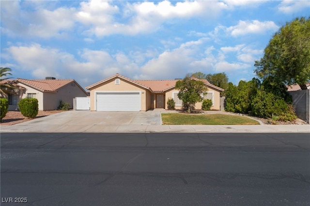 5243 Edna Crane Ave, North Las Vegas, NV 89031 - view of front of property with a garage, concrete driveway, stucco siding, and a tile roof