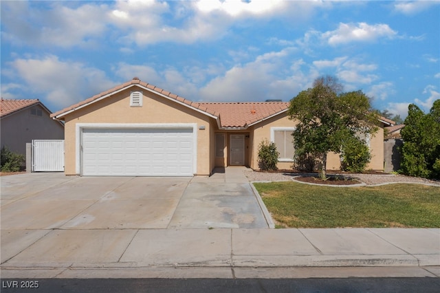 5243 Edna Crane Ave, North Las Vegas, NV 89031 - view of front of house featuring a tile roof, stucco siding, concrete driveway, a garage, and a front lawn