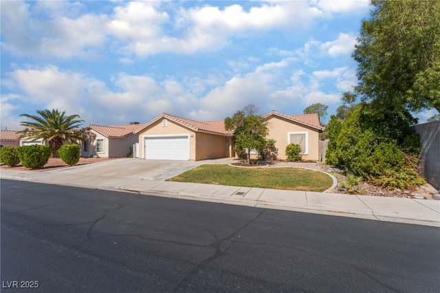5243 Edna Crane Ave, North Las Vegas, NV 89031 - mediterranean / spanish house featuring an attached garage, driveway, a tile roof, and stucco siding
