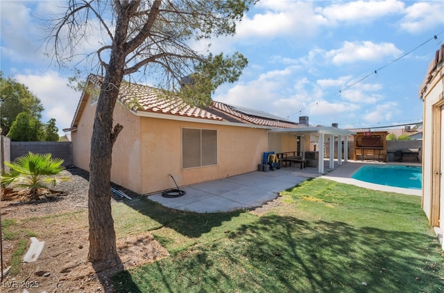 5243 Edna Crane Ave, North Las Vegas, NV 89031 - rear view of property with a fenced backyard, solar panels, stucco siding, a tiled roof, and a patio area