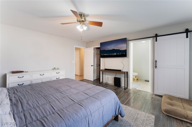 5243 Edna Crane Ave, North Las Vegas, NV 89031 - bedroom with a barn door, wood finished floors, ensuite bathroom, and a ceiling fan