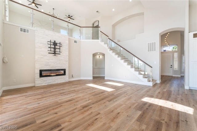1016 Eaglewood Dr, Las Vegas, NV 89144 - unfurnished living room featuring a ceiling fan, a high ceiling, healthy amount of natural light, arched walkways, and recessed lighting