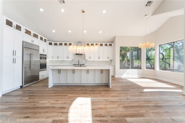 1016 Eaglewood Dr, Las Vegas, NV 89144 - kitchen featuring stainless steel appliances, tasteful backsplash, white cabinets, recessed lighting, and vaulted ceiling