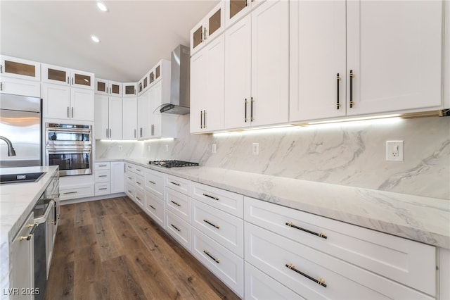 1016 Eaglewood Dr, Las Vegas, NV 89144 - kitchen with wall chimney exhaust hood, stainless steel appliances, tasteful backsplash, white cabinets, and dark wood-style flooring