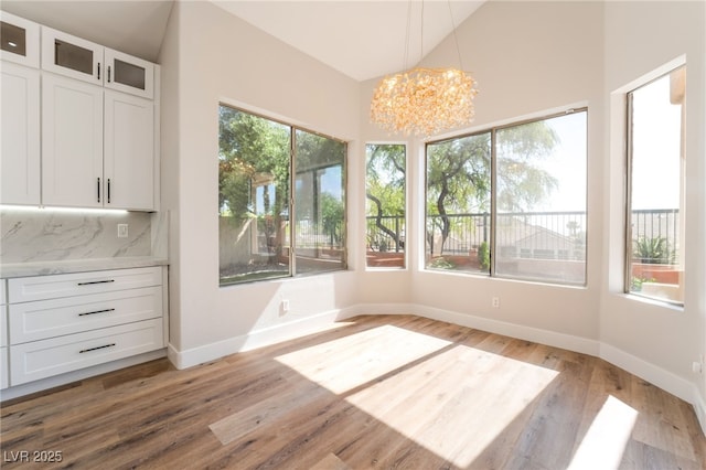 1016 Eaglewood Dr, Las Vegas, NV 89144 - unfurnished dining area with a chandelier, light wood-style flooring, and vaulted ceiling