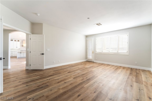 1016 Eaglewood Dr, Las Vegas, NV 89144 - empty room featuring arched walkways, a smoke detector, and wood finished floors