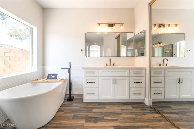 1016 Eaglewood Dr, Las Vegas, NV 89144 - bathroom featuring a freestanding tub, two vanities, plenty of natural light, and wood finished floors