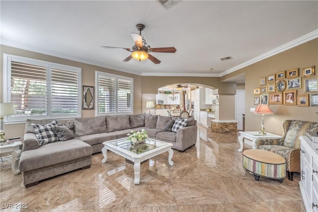 56 Ancient Hills Ln, Henderson, NV 89074 - living room featuring arched walkways, ornamental molding, ceiling fan, light marble finish floors, and ornate columns