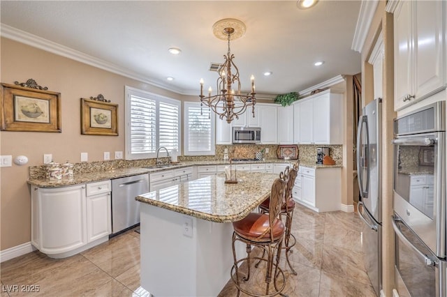 56 Ancient Hills Ln, Henderson, NV 89074 - kitchen with stainless steel appliances, crown molding, a center island, white cabinets, and recessed lighting