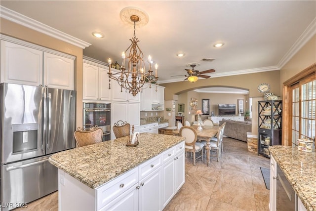 56 Ancient Hills Ln, Henderson, NV 89074 - kitchen featuring appliances with stainless steel finishes, arched walkways, ornamental molding, a chandelier, and light stone counters